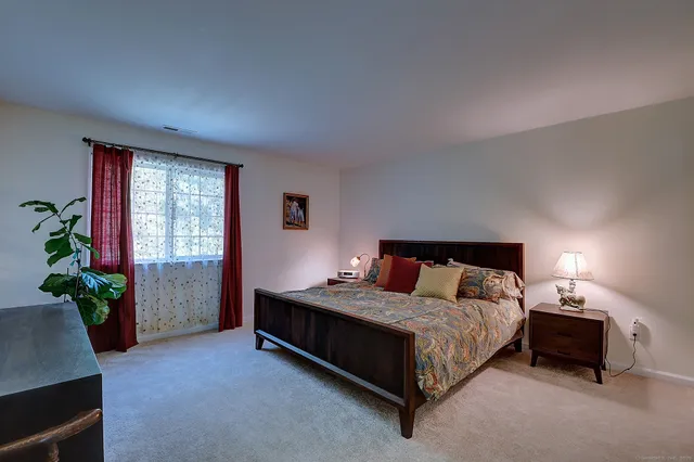 a bedroom with a bed lamp and a potted plant