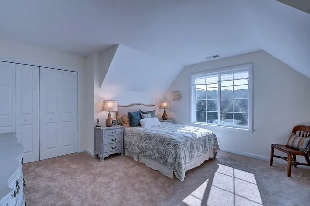 a bedroom with a bed and a table chair