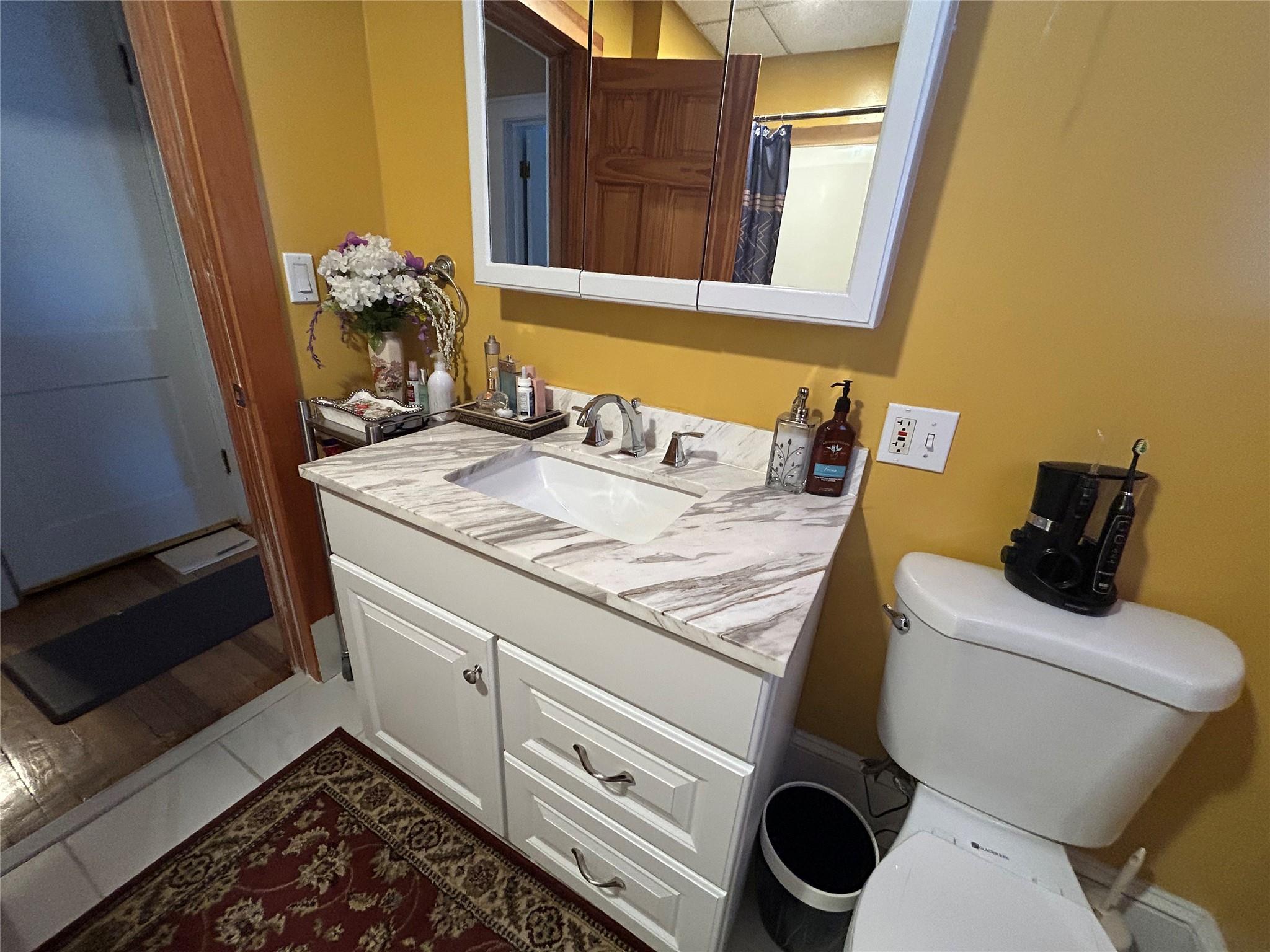 199 Washington Street Poughkeepsie, NY 12601 - Photo 16 of 32 Bathroom featuring toilet, tile patterned flooring, and vanity