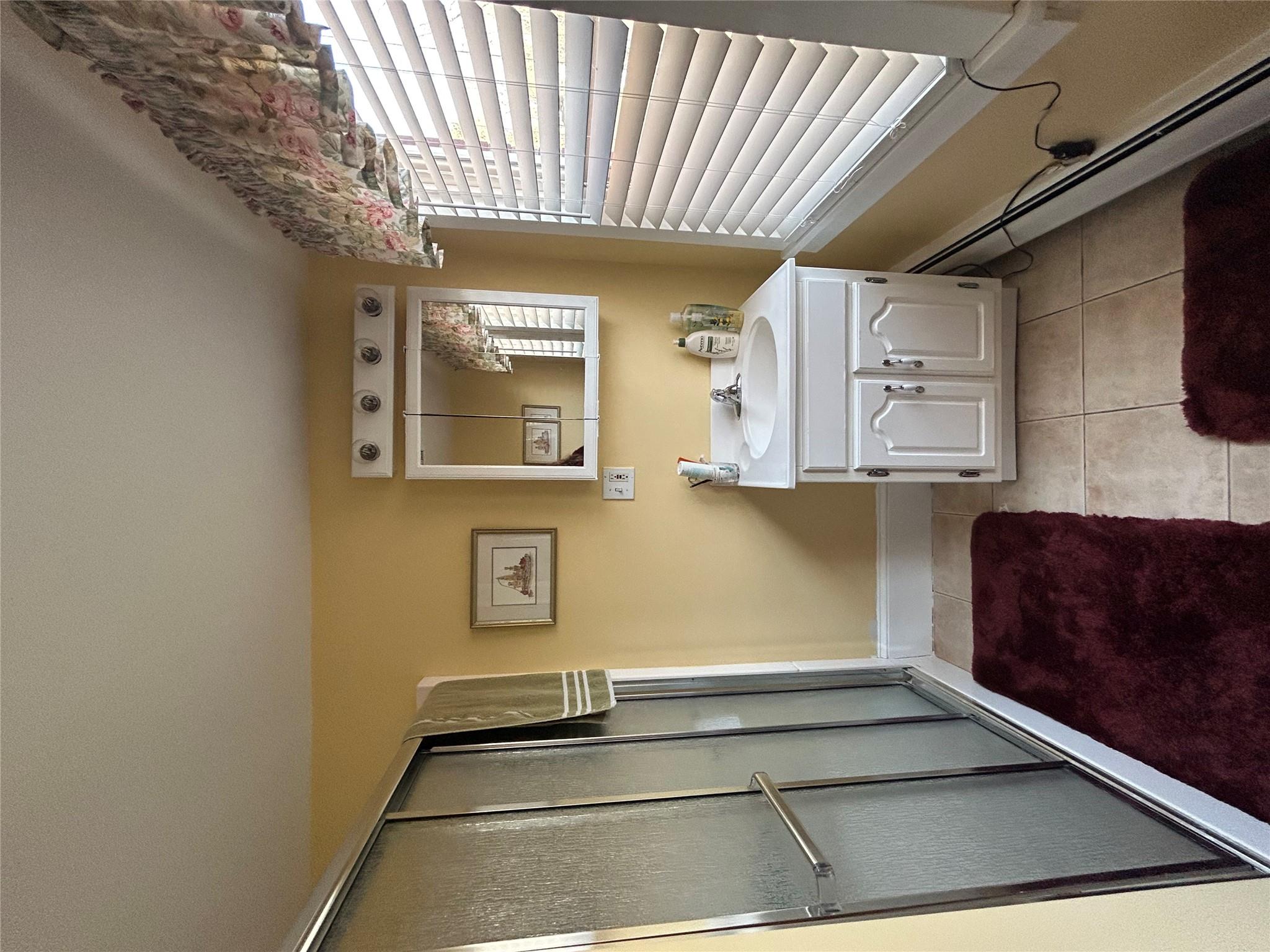 199 Washington Street Poughkeepsie, NY 12601 - Photo 20 of 32 Bathroom with a baseboard heating unit, tile patterned flooring, a shower stall, and vanity
