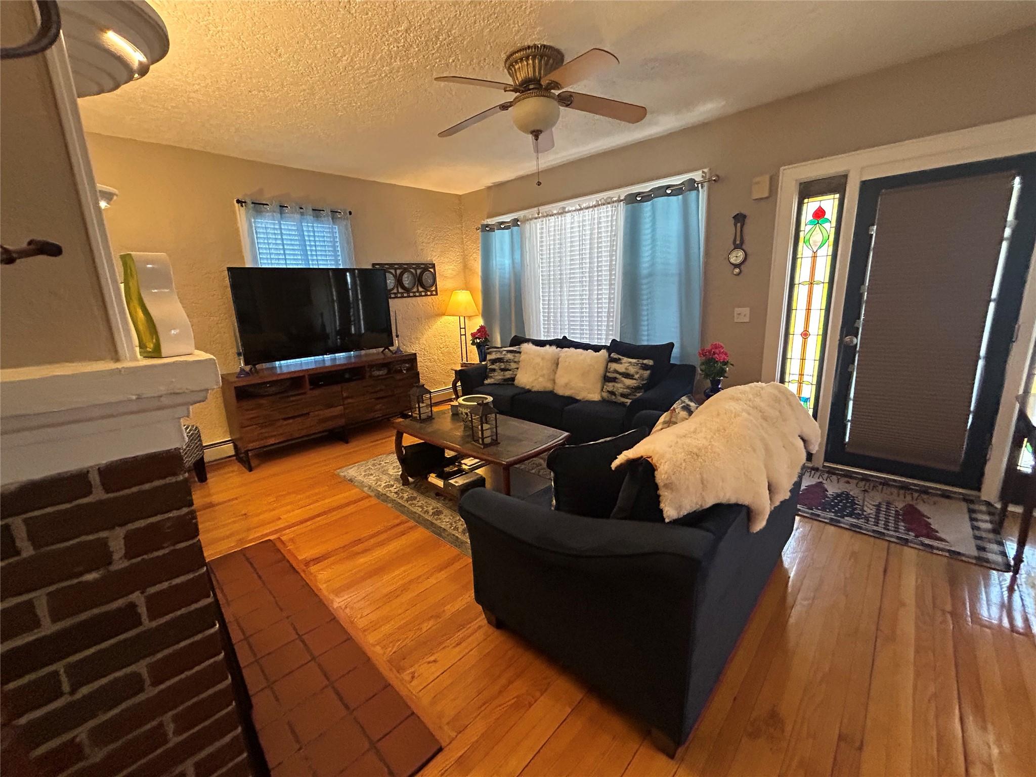 199 Washington Street Poughkeepsie, NY 12601 - Photo 10 of 32 Living area with a textured ceiling, ceiling fan, hardwood / wood-style floors, and a wealth of natural light