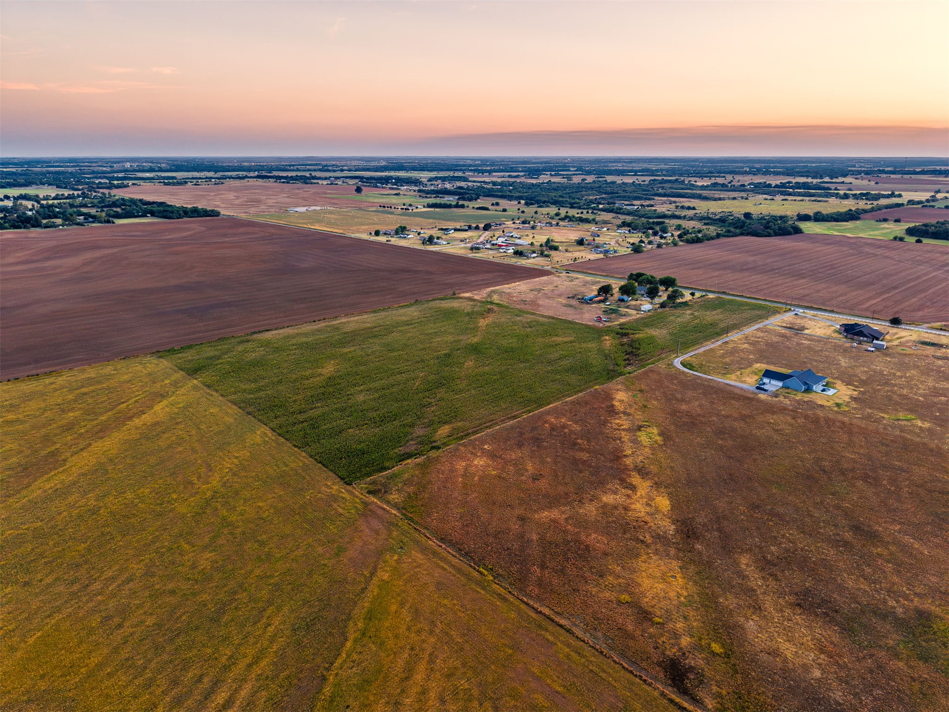 16 North Gregory Road Yukon, OK 73099 - Photo 26 of 34 Expansive agricultural land featuring a mix of cultivated fields and undeveloped areas, with a distant residential structure