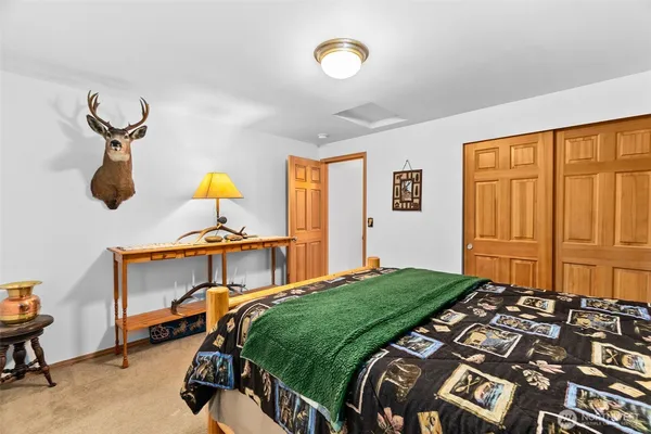a bedroom with a bed and painting on the wall