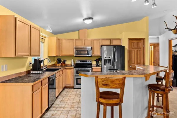 a kitchen with stainless steel appliances a stove refrigerator sink and cabinets