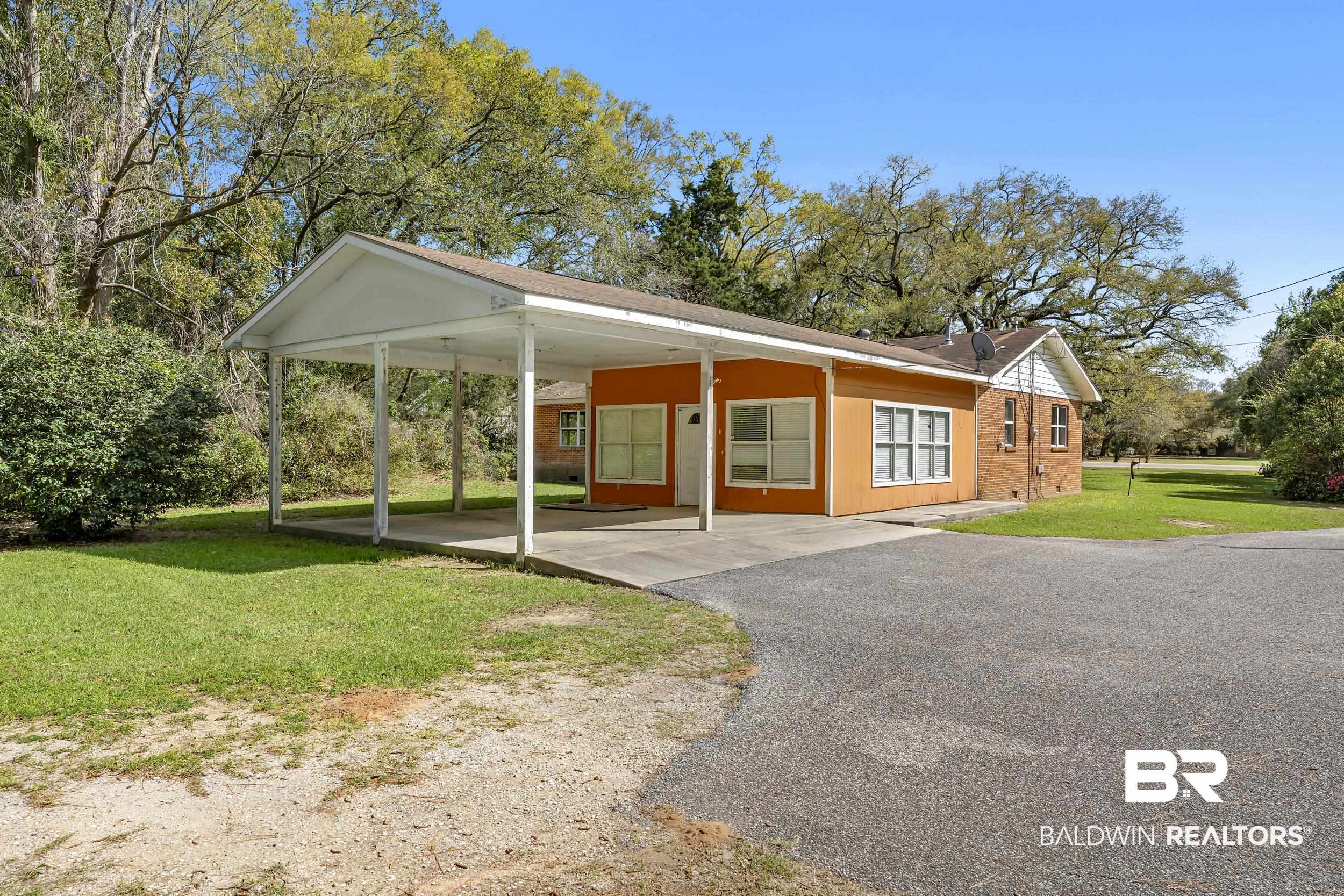17463 Highway 98 Foley, AL 36535 - Photo 21 of 57 View of front of home featuring a front lawn, a carport, asphalt driveway, a porch, and brick siding