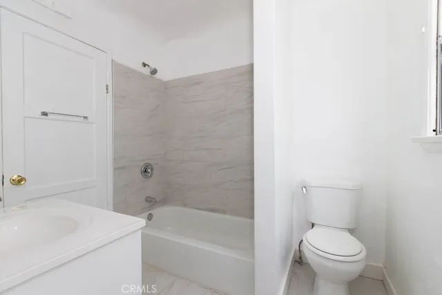 a white toilet sitting next to a bath tub