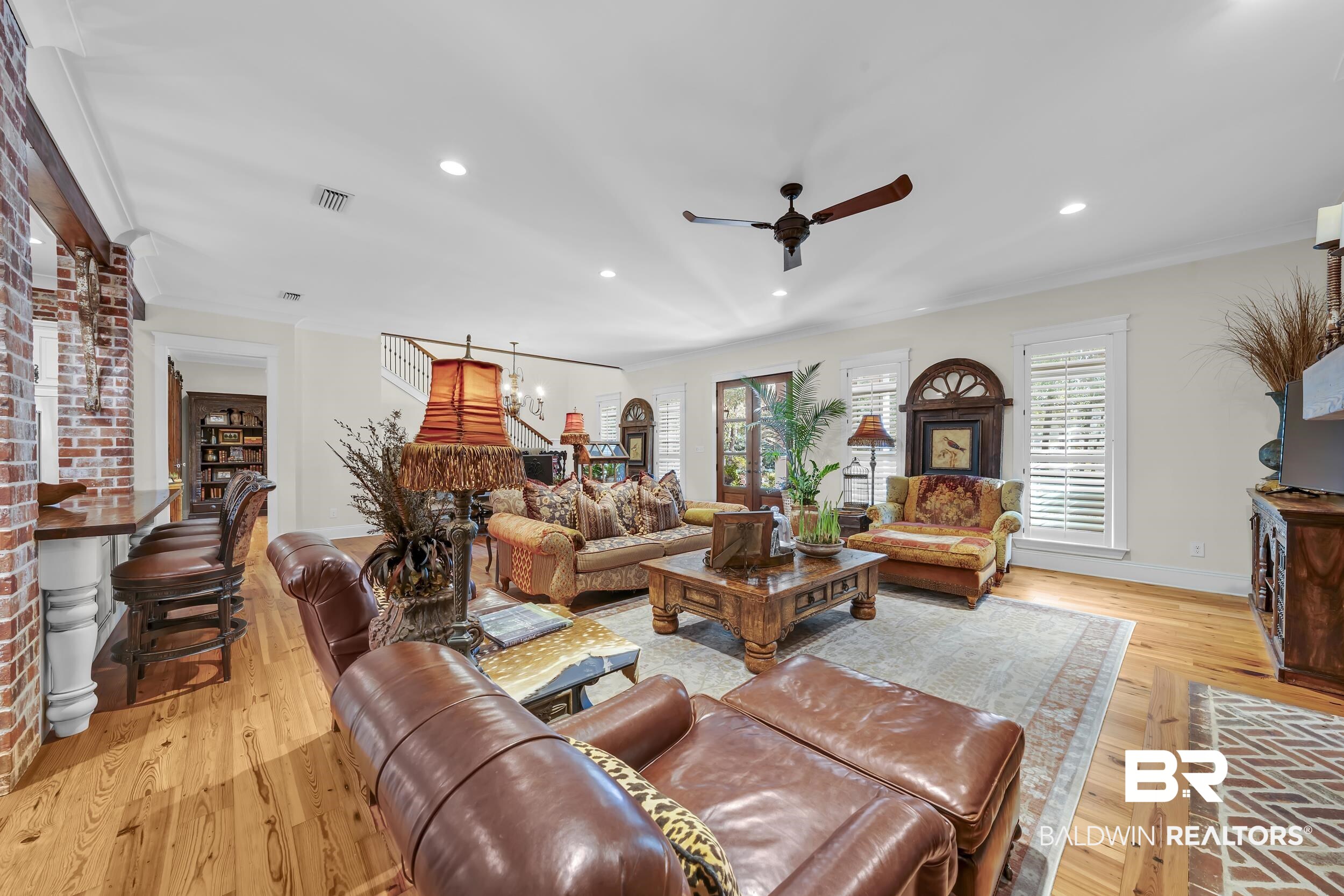 12161 Jessamine Street Magnolia Springs, AL 36555 - Photo 7 of 70 Living area featuring light wood-style floors, a ceiling fan, ornamental molding, and a chandelier