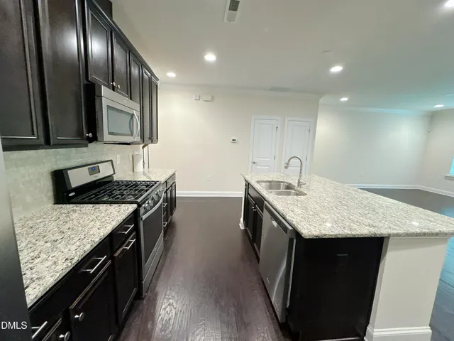 a kitchen with kitchen island granite countertop wooden cabinets and a stainless steel appliances
