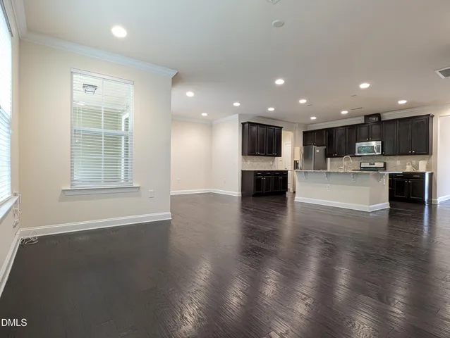 a kitchen with granite countertop center island wooden floor and stainless steel appliances
