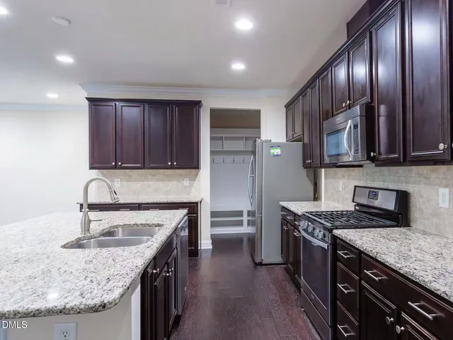 a kitchen with granite countertop wood cabinets and a stainless steel appliances