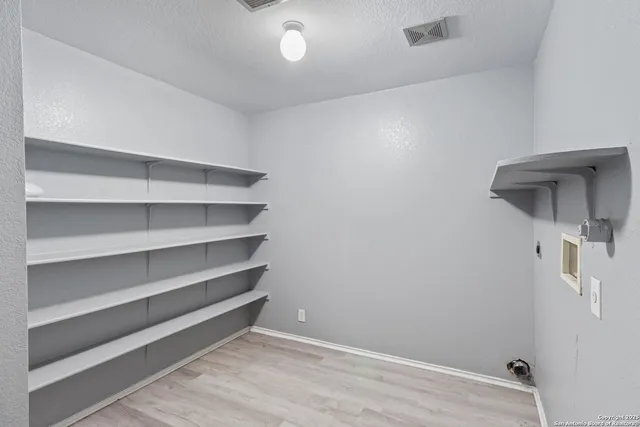 a view of walk in closet with empty racks