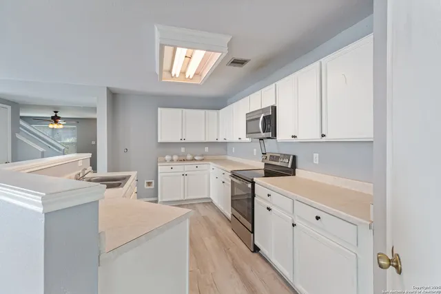 a kitchen with granite countertop white cabinets and white appliances