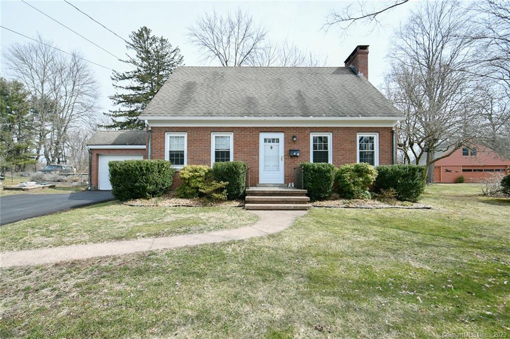 a front view of house with yard and trees around