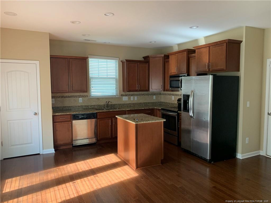 261 River Oaks St Spring Lake Spring Lake, NC 28390 - Photo 11 of 38 a kitchen with granite countertop wooden floors a refrigerator and cabinets