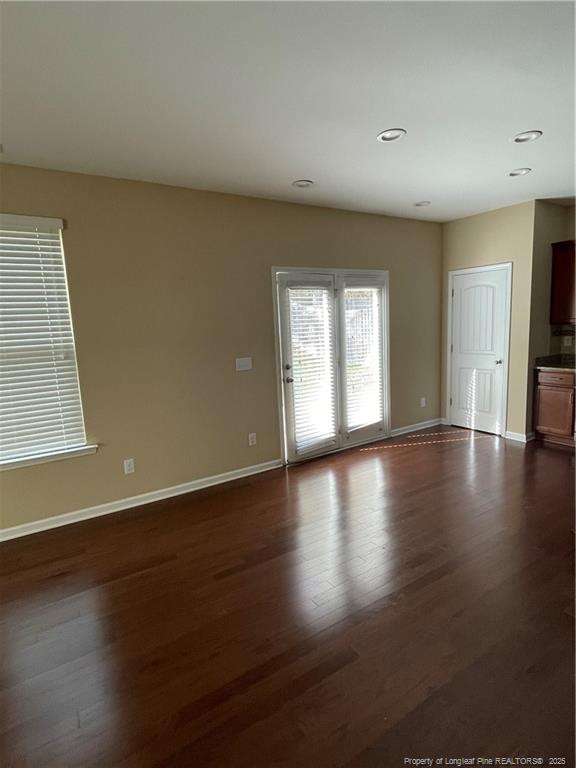 261 River Oaks St Spring Lake Spring Lake, NC 28390 - Photo 8 of 38 an empty room with wooden floor and windows with curtains