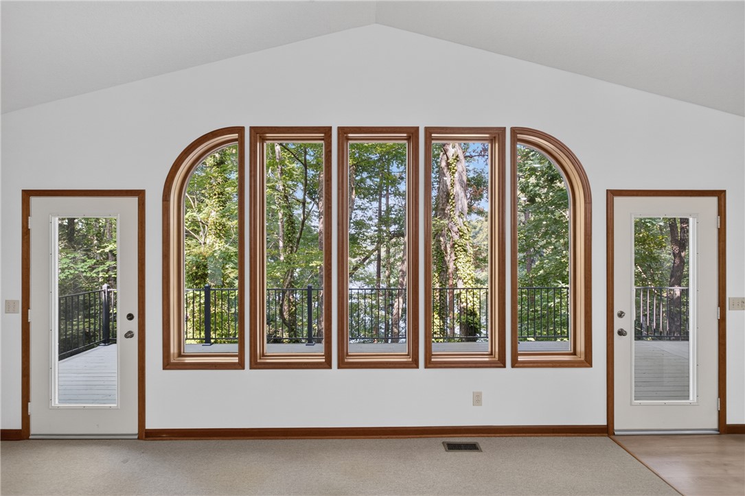 12 Lookout Lane Salem, SC 29676 - Photo 10 of 47 A spacious room offers captivating views of surrounding nature through arched and rectangular window frames.