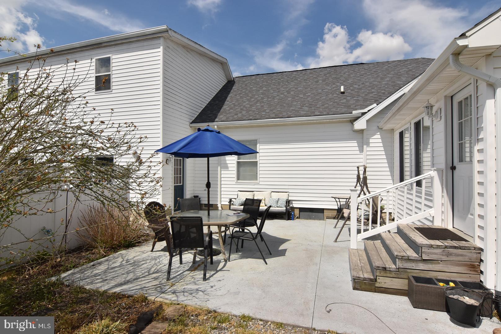 24531 Shortly Road Georgetown, DE 19947 - Photo 6 of 30 a view of a patio with table and chairs under an umbrella