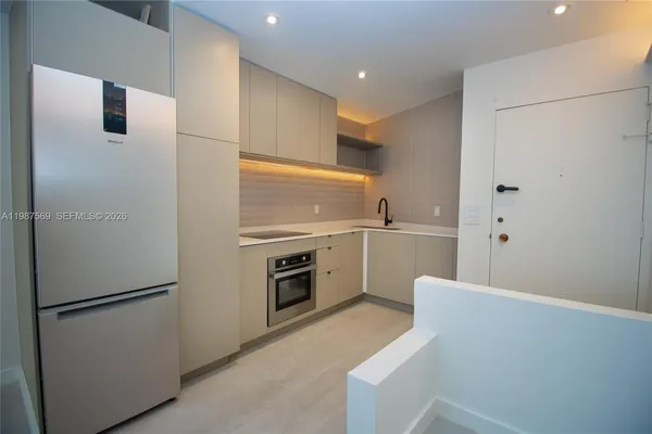 a kitchen with a refrigerator sink stove and cabinets