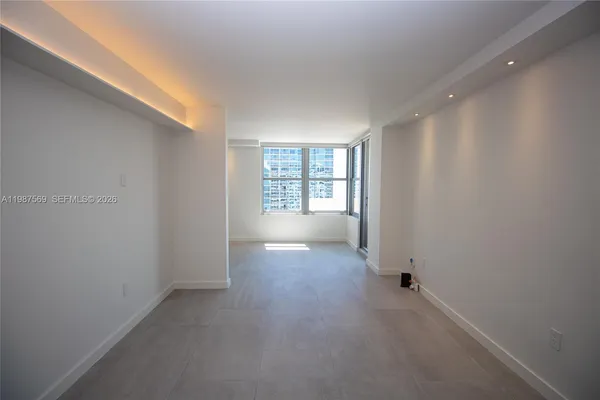 an empty room with windows and closet