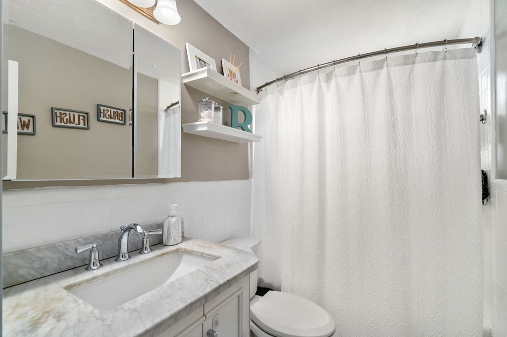 172 Circle Drive Waltham, MA 02452 - Photo 16 of 23 a bathroom with a granite countertop sink and a mirror