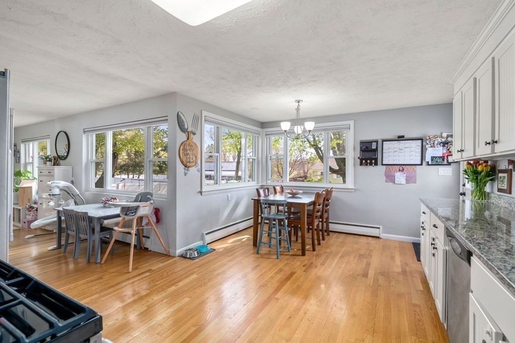 172 Circle Drive Waltham, MA 02452 - Photo 8 of 23 a dining room with wooden floor and large windows