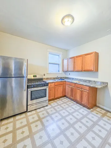 a kitchen with granite countertop a sink cabinets and stainless steel appliances