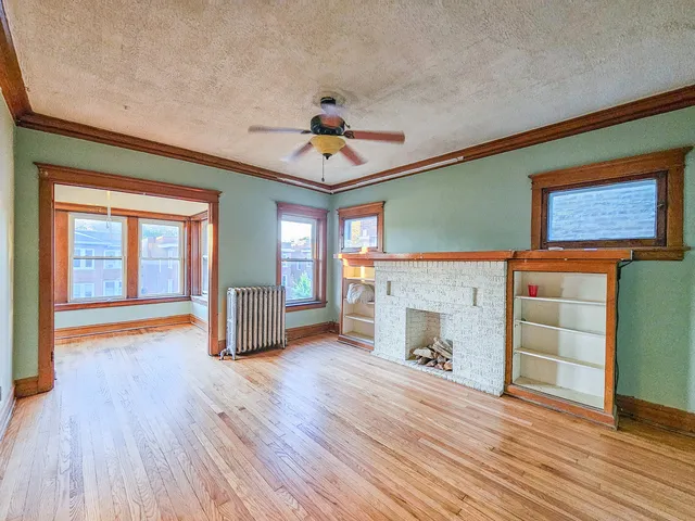 wooden floor fireplace and windows in an empty room