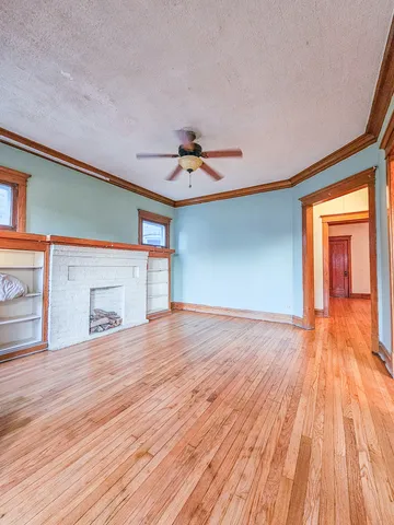 a view of an empty room with a window and wooden floor