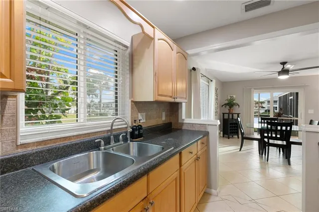 a kitchen with stainless steel appliances granite countertop a sink a oven a dining table and chairs with wooden floor