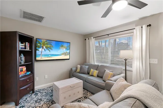 a living room with furniture a window and a flat screen tv