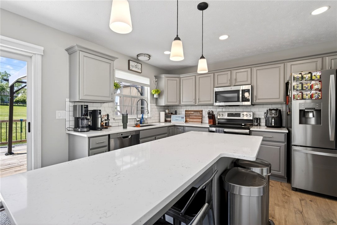 39 Holly Court Springboro, OH 45066 - Photo 10 of 42 This modern kitchen features a sleek design, stainless steel appliances, and a convenient breakfast bar.