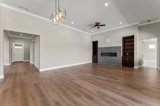a view of an empty room with a window and fireplace