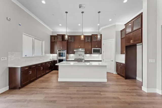 a kitchen with stainless steel appliances granite countertop a stove refrigerator and a wooden floor