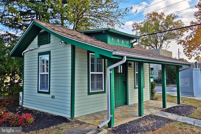 a view of a house with a small yard plants and large tree