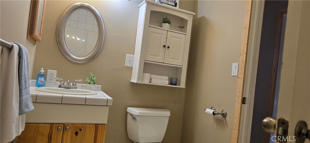 3020 Lebec Oaks Road Lebec, CA 93243 - Photo 9 of 12 a bathroom with a toilet a sink and mirror