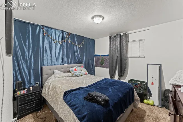 a bedroom with a bed and a flat tv screen