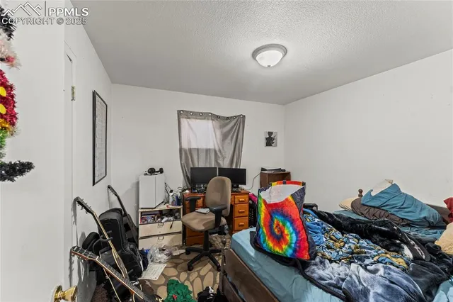 a living room with furniture and a baby crib