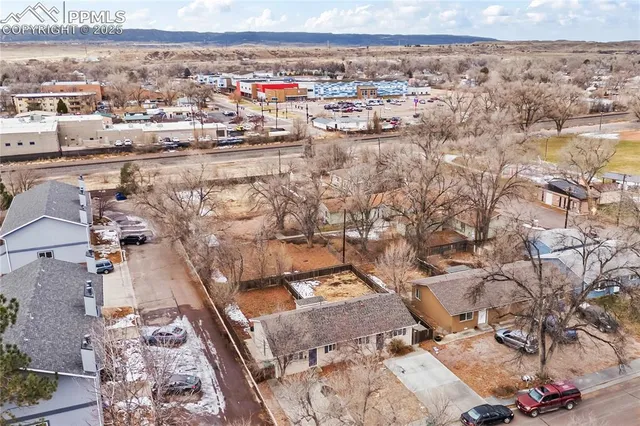 a view of a house next to a yard with large trees