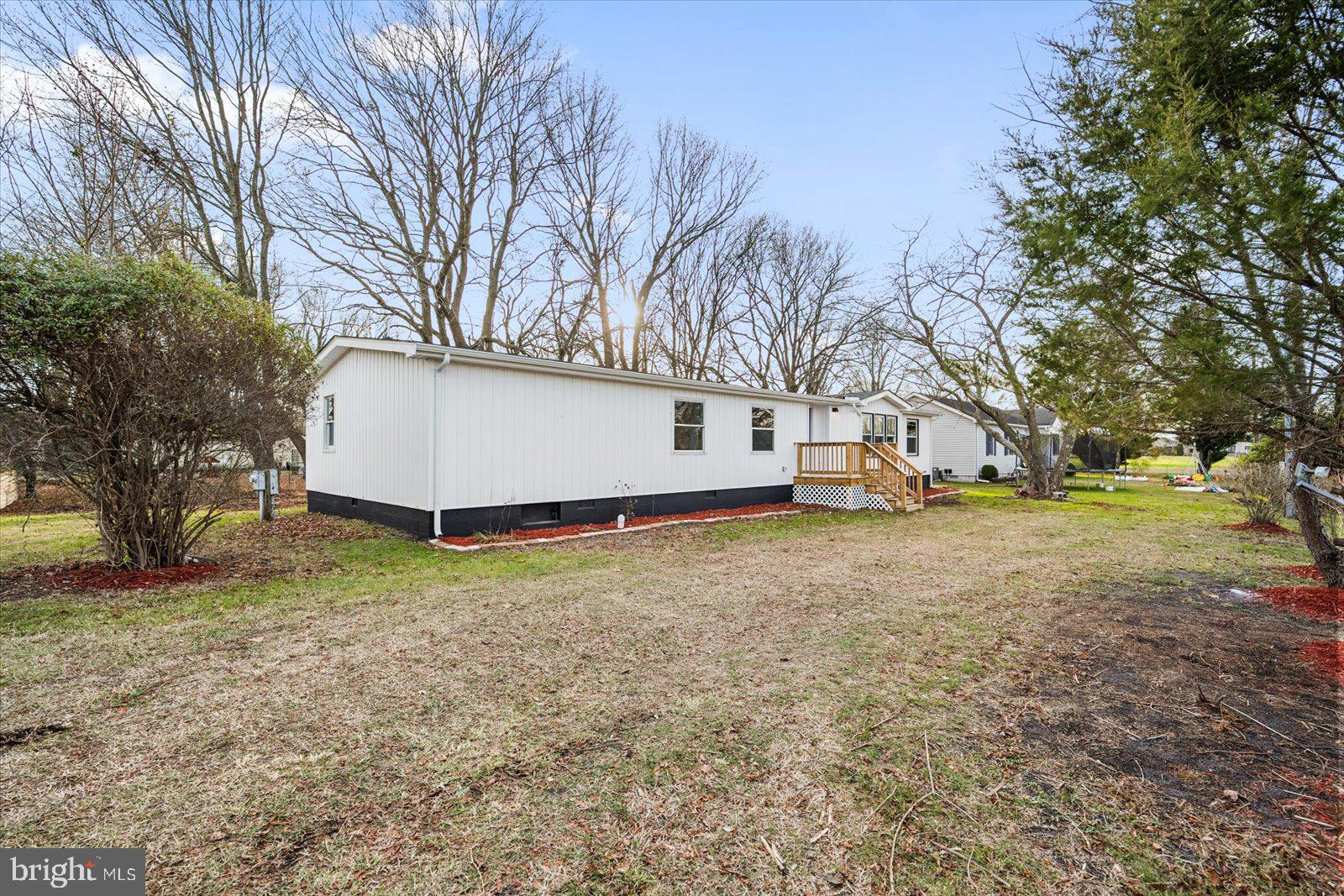 36451-3 3 Bridges Road Willards, MD 21874 - Photo 2 of 44 a view of a white house next to a yard with a large tree