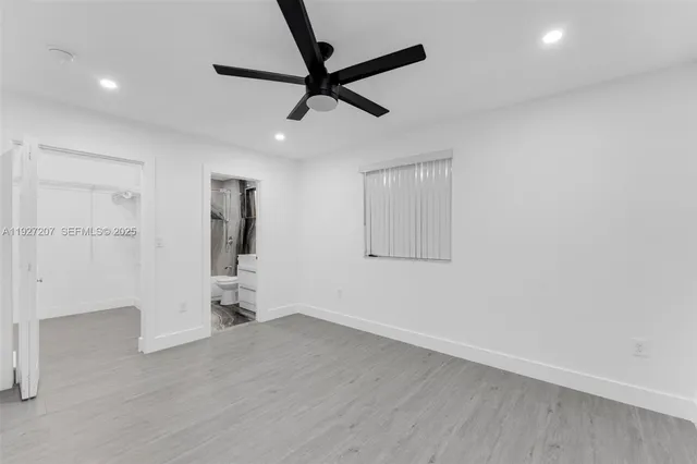 a bathroom with a granite countertop bathtub shower sink vanity and toilet