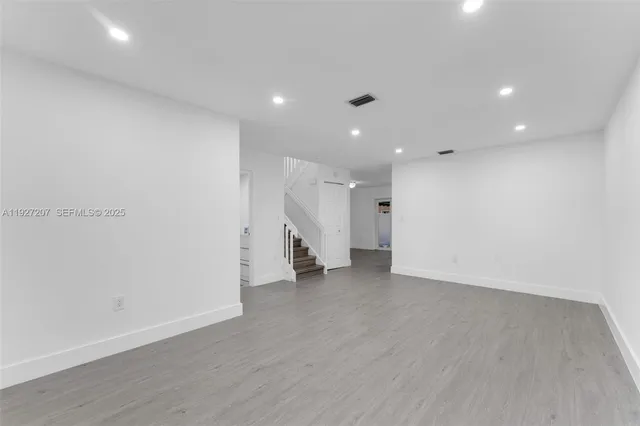 an empty room with wooden floor and white walls