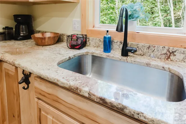 a kitchen with a granite countertop sink and a window