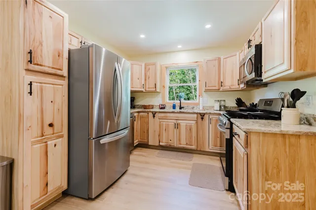 a kitchen with stainless steel appliances granite countertop a refrigerator sink and cabinets