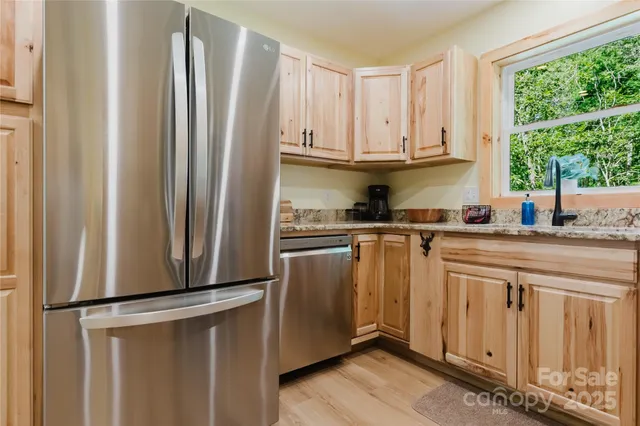 a kitchen with stainless steel appliances a refrigerator and a window
