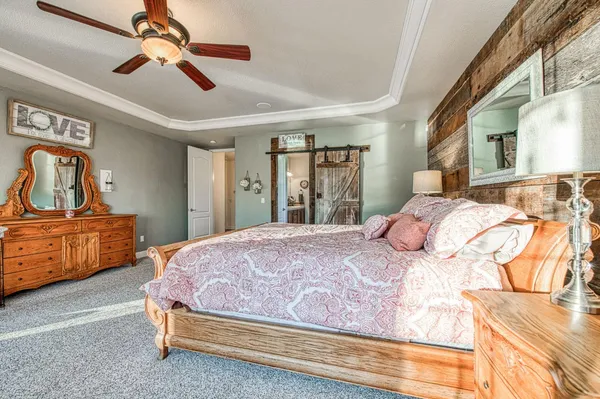 an empty room with chandelier fan and windows