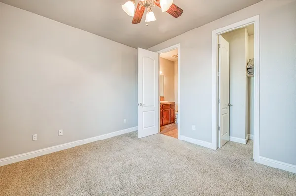 an empty room with a chandelier fan