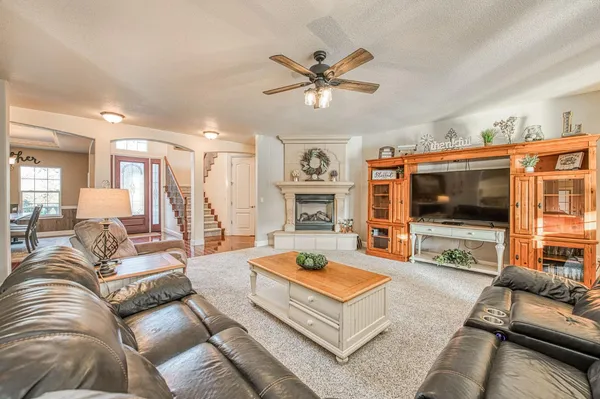 a kitchen with stainless steel appliances granite countertop a stove top oven a sink a dining table and chairs with wooden floor