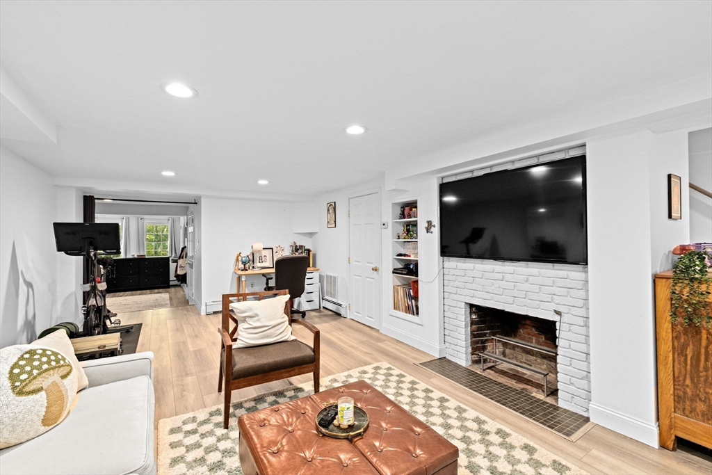 23 Mast Hill Road Hingham, MA 02043 - Photo 30 of 42 a living room with furniture a flat screen tv and a fireplace
