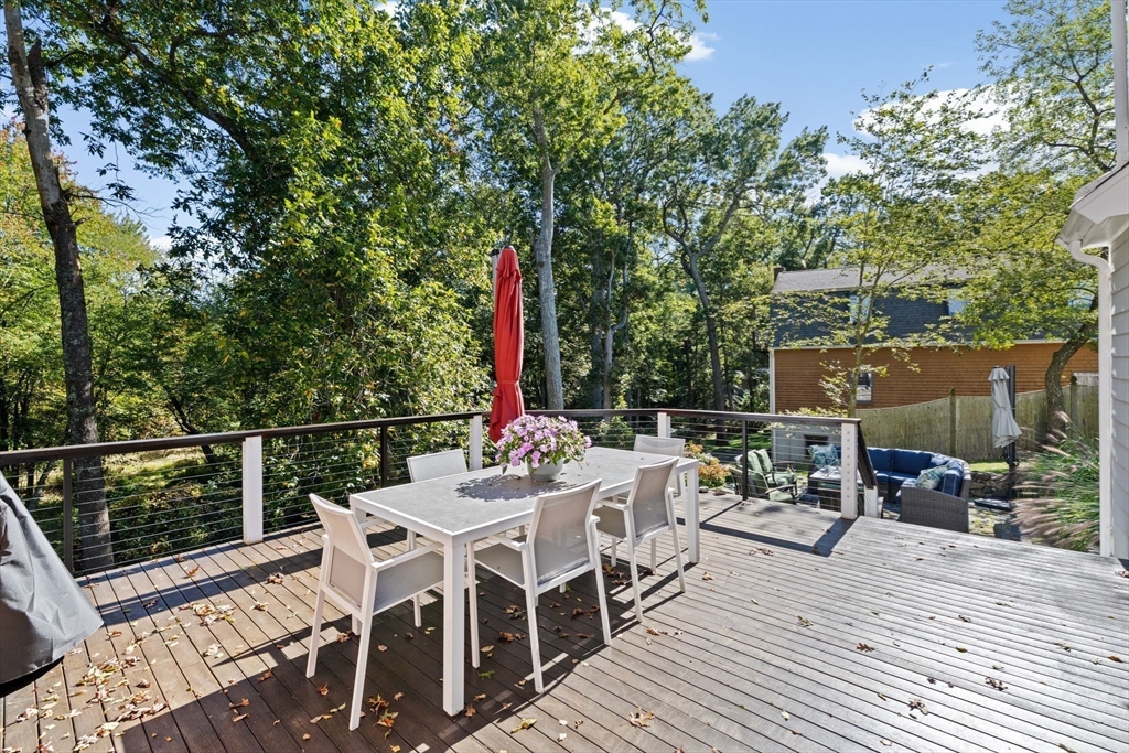 23 Mast Hill Road Hingham, MA 02043 - Photo 35 of 42 a view of a roof deck with table and chairs couches and a barbeque with wooden fence and floor