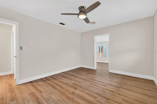 a view of empty room with wooden floor